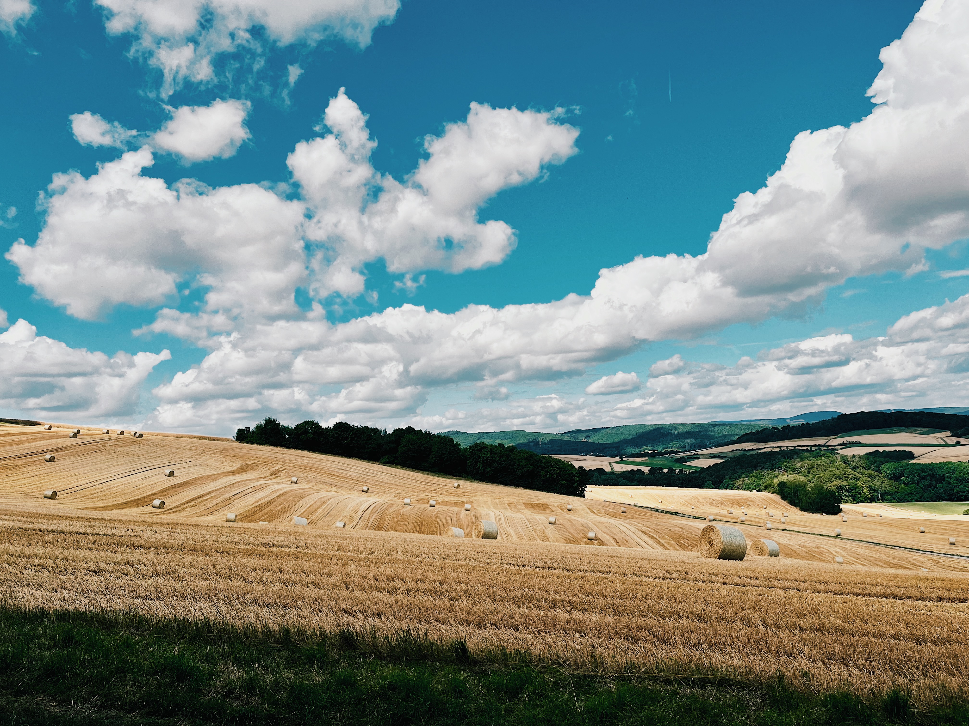 Wide view over straw fields with thick clouds on a summer sky in Germany